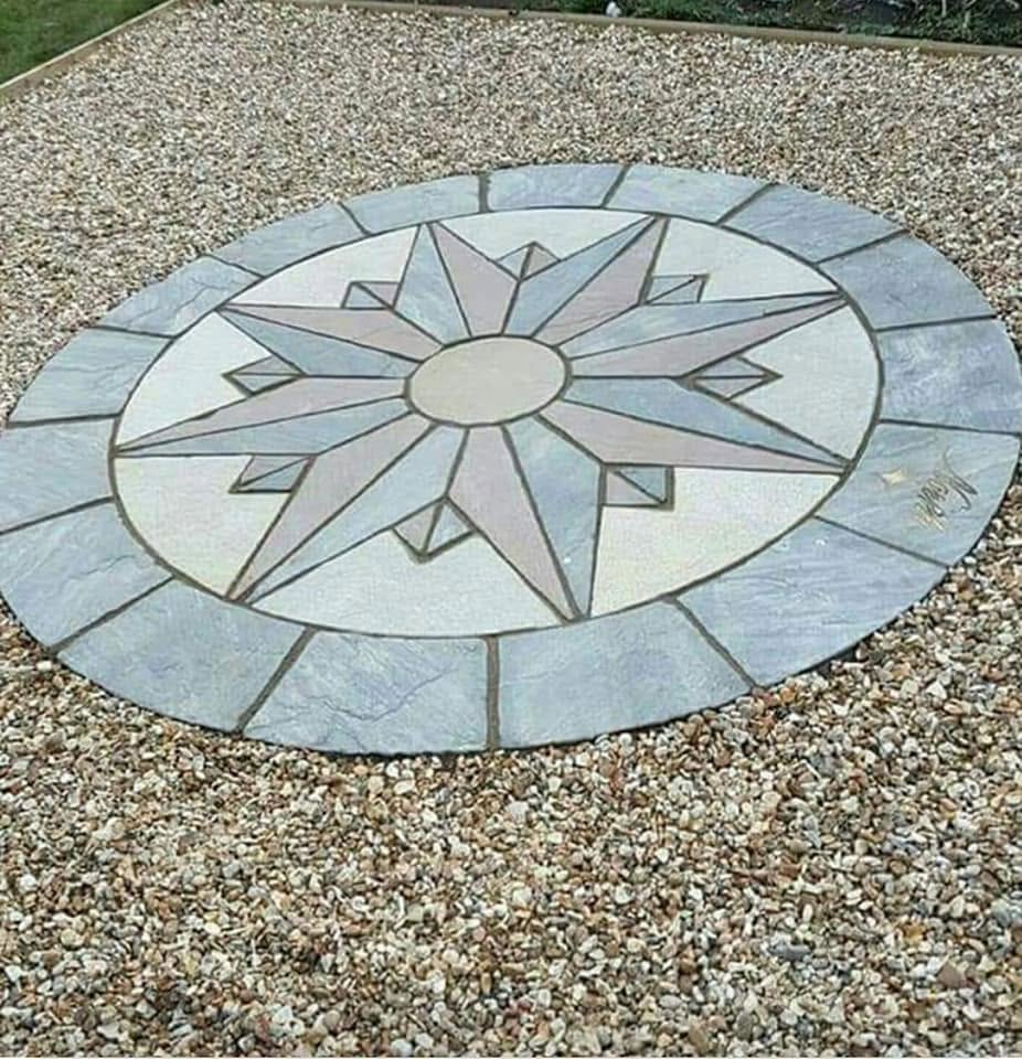 Circular compass-star paving feature set into a gravel garden