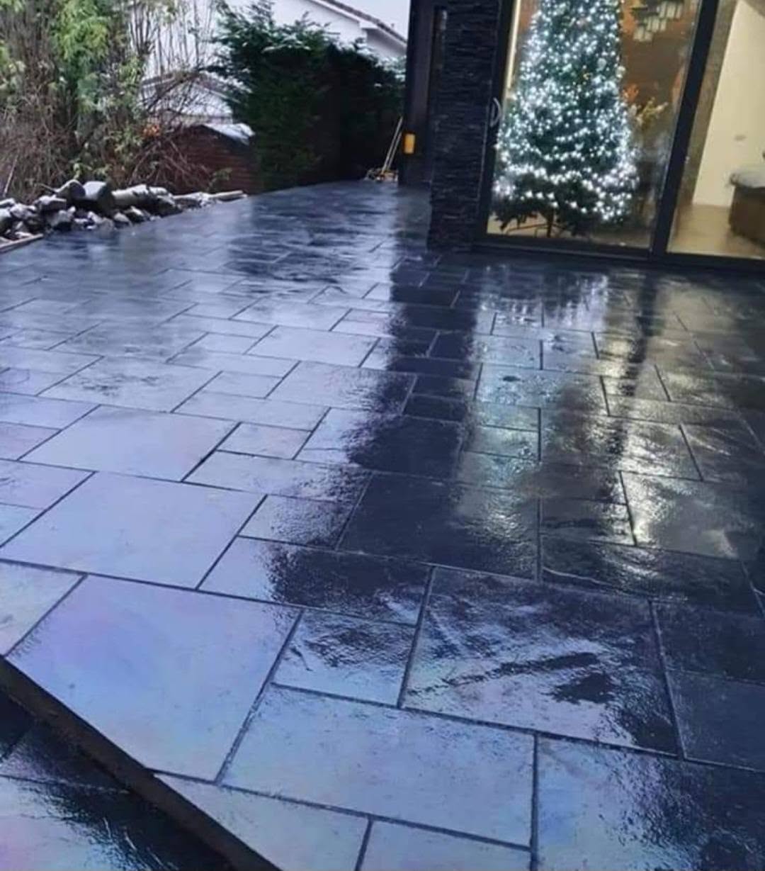 Dark slate-look patio in the evening beside a stone-clad pillar